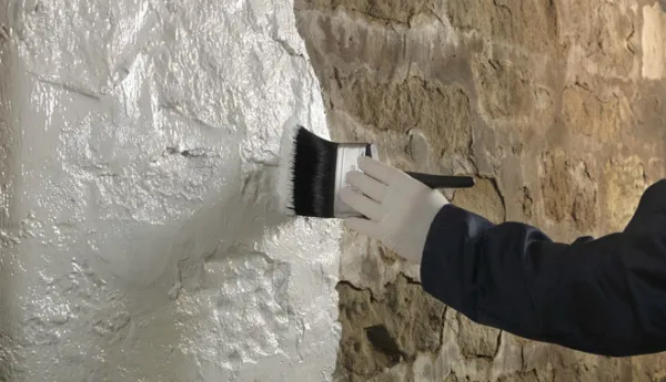Нанесение адгезионного грунта кистью на стену